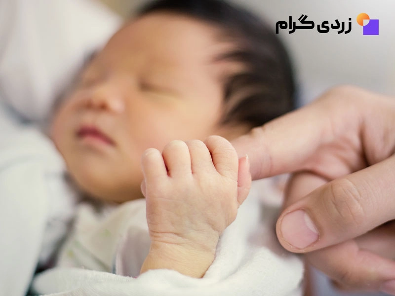 کودک مبتلا به زردی که دست مادر خود را گرفته است